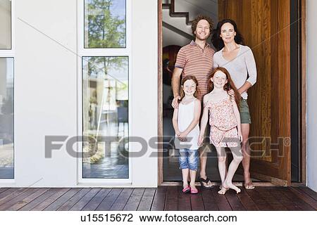 Stock Image - Family smiling at front door. Fotosearch