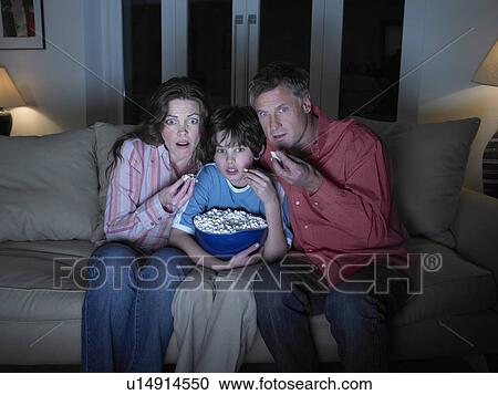 Stock Image - Family watching movie together. Fotosearch