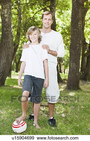Father and son smiling in park View Large Photo Image Stock Photo - Father and son smiling in park. Fotosearch