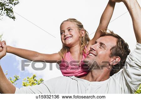 Father carrying daughter in park View Large Photo Image Stock Photograph - Father carrying daughter in park. Fotosearch
