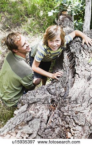 Father helping son over fallen tree View Large Photo Image Stock Photo - Father helping son over fallen tree. Fotosearch