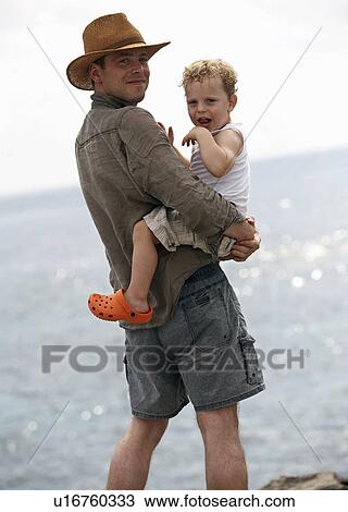 Father holding son outdoors View Large Photo Image Stock Image - Father holding son outdoors. Fotosearch