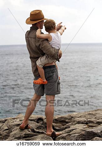 Stock Photo - Father holding son outdoors. Fotosearch