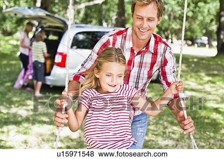 Father pushing daughter on swing View Large Photo Image Stock Photo - Father pushing daughter on swing. Fotosearch