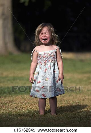 Stock Photography - Girl crying in backyard. Fotosearch