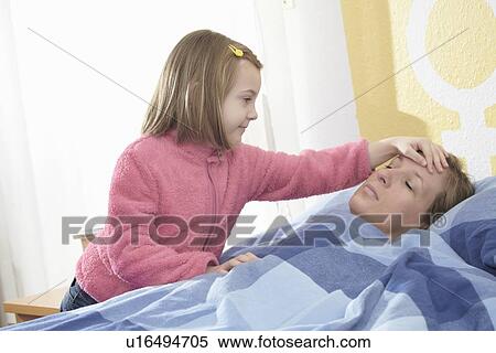 Stock Photography - Girl feeling sick mothers forehead. Fotosearch
