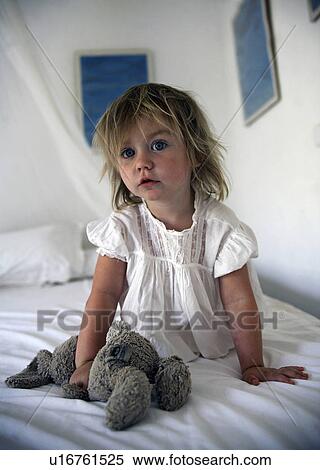 Girl holding teddy bear on bed View Large Photo Image Stock Photography - Girl holding teddy bear on bed. Fotosearch