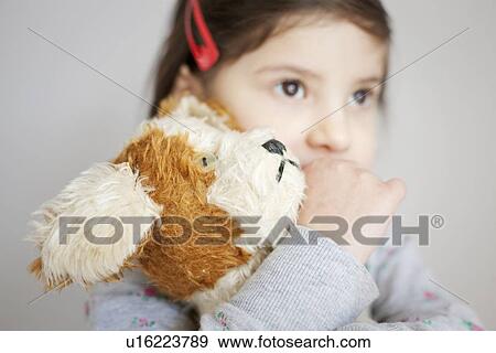 Stock Photo - Girl hugging teddy bear. Fotosearch