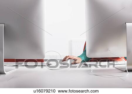 Stock Image - Girl using computer at desk. Fotosearch