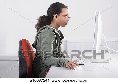 Girl using computer at desk View Large Photo Image Stock Image - Girl using computer at desk. Fotosearch