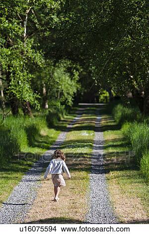 Picture - Girl walking on rural road. Fotosearch