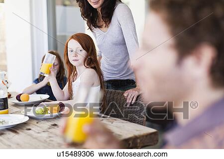 Girl watching father drink orange juice View Large Photo Image Stock Photograph - Girl watching father drink orange juice. Fotosearch