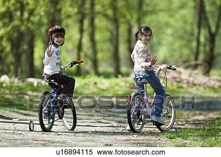 Girls riding bicycles in park View Large Photo Image Stock Photography - Girls riding bicycles in park. Fotosearch