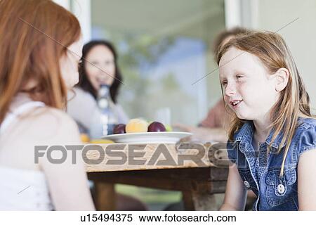 Stock Photography - Girls talking at breakfast table. Fotosearch