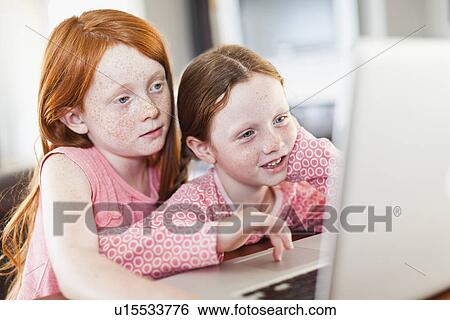 Stock Photograph - Girls using laptop together. Fotosearch