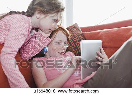 Girls using tablet computer together View Large Photo Image Stock Photo - Girls using tablet computer together. Fotosearch