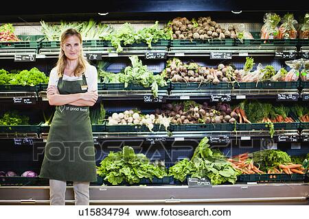 Grocer smiling in produce section View Large Photo Image Picture - Grocer smiling in produce section. Fotosearch