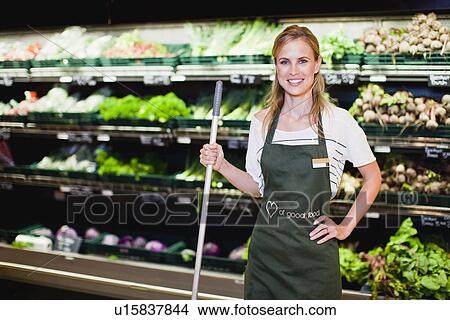 Picture - Grocer smiling in produce section. Fotosearch