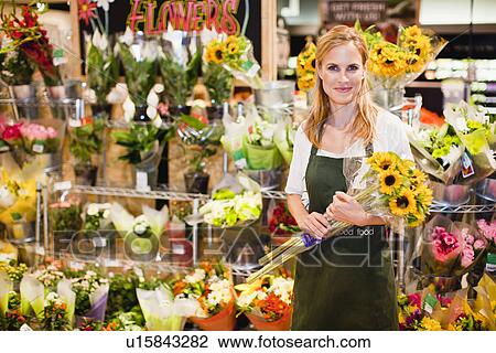 Grocer working in florist section View Large Photo Image Stock Image - Grocer working in florist section. Fotosearch