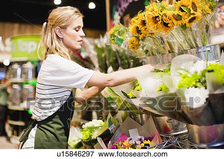 Stock Photo - Grocer working in florist section. Fotosearch