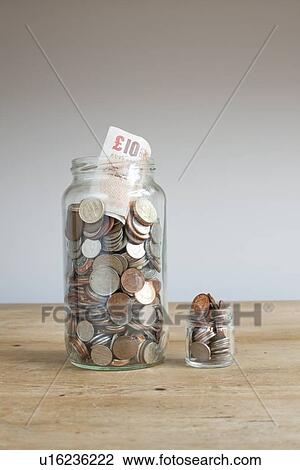 Large and small savings jars on desk View Large Photo Image Stock Image - Large and small savings jars on desk. Fotosearch