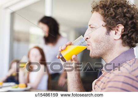 Man drinking glass of orange juice View Large Photo Image Stock Photo - Man drinking glass of orange juice. Fotosearch