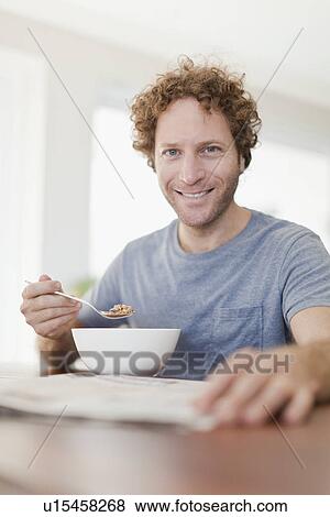 Man reading newspaper at breakfast View Large Photo Image Stock Photo - Man reading newspaper at breakfast. Fotosearch