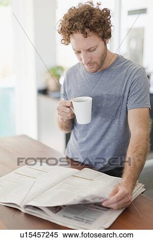 Stock Photography - Man reading newspaper at breakfast. Fotosearch
