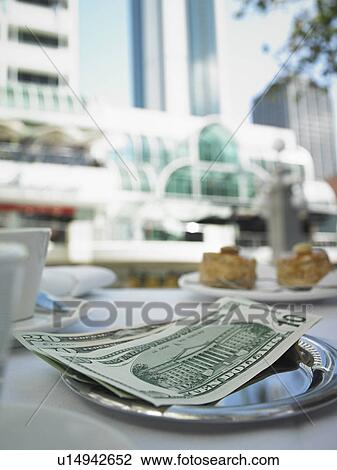 Stock Image - Money in tray on restaurant table. Fotosearch