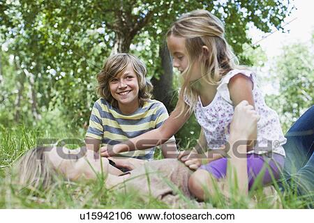 Stock Photograph - Mother and children playing in park. Fotosearch