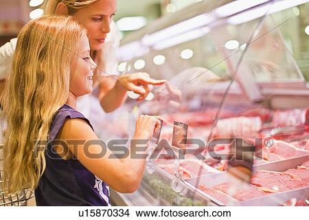 Mother and daughter at butcher counter View Large Photo Image Picture - Mother and daughter at butcher counter. Fotosearch