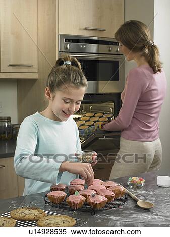 Stock Photography - Mother and daughter baking together. Fotosearch