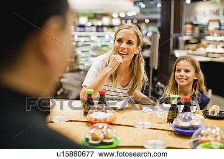 Stock Photo - Mother and daughter eating at deli. Fotosearch