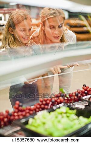 Stock Image - Mother and daughter in grocery store. Fotosearch