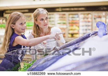 Stock Photo - Mother and daughter in grocery store. Fotosearch