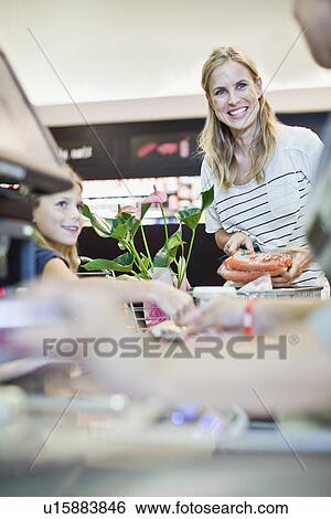 Stock Photograph - Mother and daughter in grocery store. Fotosearch