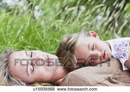 Mother and daughter napping in grass View Large Photo Image Stock Photo - Mother and daughter napping in grass. Fotosearch