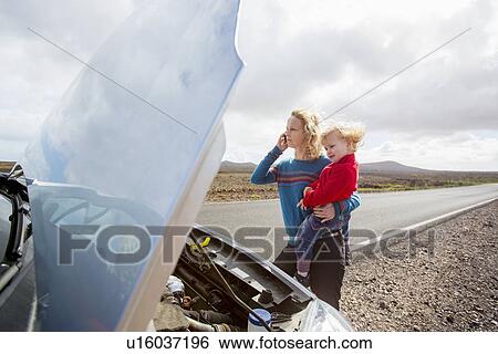 Stock Photograph - Mother and daughter with broken down car. Fotosearch
