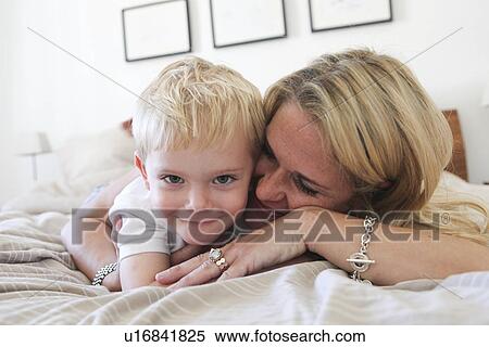 Stock Photography - Mother and son laying on bed. Fotosearch