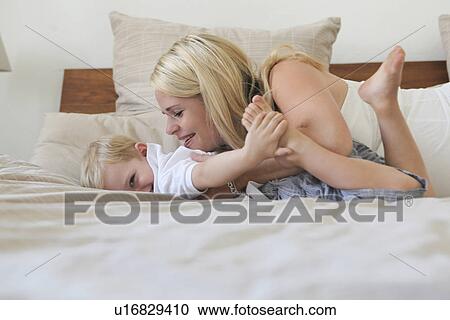 Mother and son playing on bed View Large Photo Image Stock Image - Mother and son playing on bed. Fotosearch