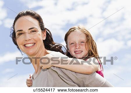 Stock Photo - Mother carrying daughter piggyback. Fotosearch