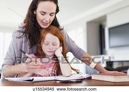 Mother helping daughter with homework View Large Photo Image Stock Photography - Mother helping daughter with homework. Fotosearch