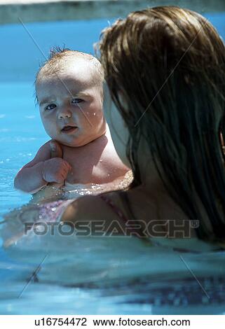 Mother holding baby in swimming pool View Large Photo Image Stock Image - Mother holding baby in swimming pool. Fotosearch