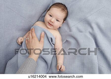 Mother patting baby boy in bed View Large Photo Image Picture - Mother patting baby boy in bed. Fotosearch