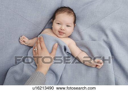 Mother patting baby boy in bed View Large Photo Image Stock Image - Mother patting baby boy in bed. Fotosearch