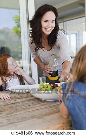 Mother serving daughters breakfast View Large Photo Image Stock Photograph - Mother serving daughters breakfast. Fotosearch