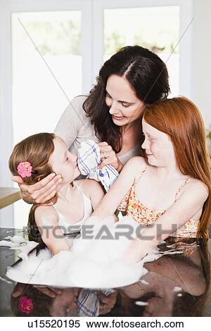 Mother wiping daughters face in kitchen View Large Photo Image Stock Photography - Mother wiping daughters face in kitchen. Fotosearch