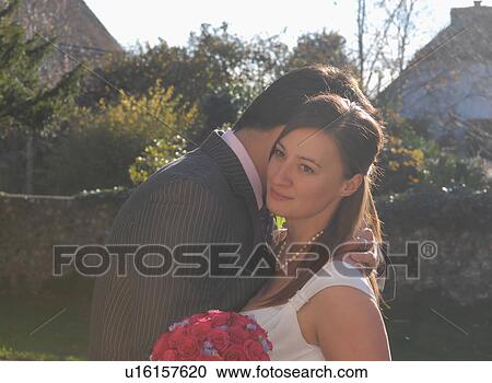 Stock Image - Newlywed couple hugging outdoors. Fotosearch