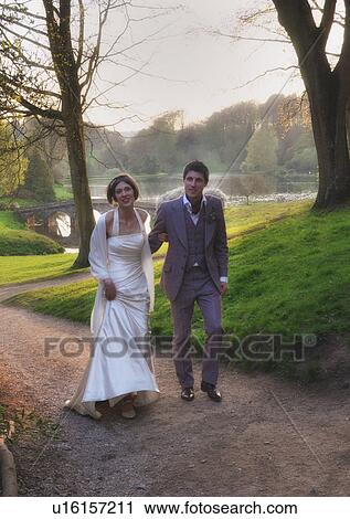 Stock Image - Newlywed couple walking outdoors. Fotosearch