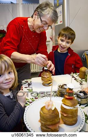 Stock Photography - Older woman baking with grandchildren. Fotosearch